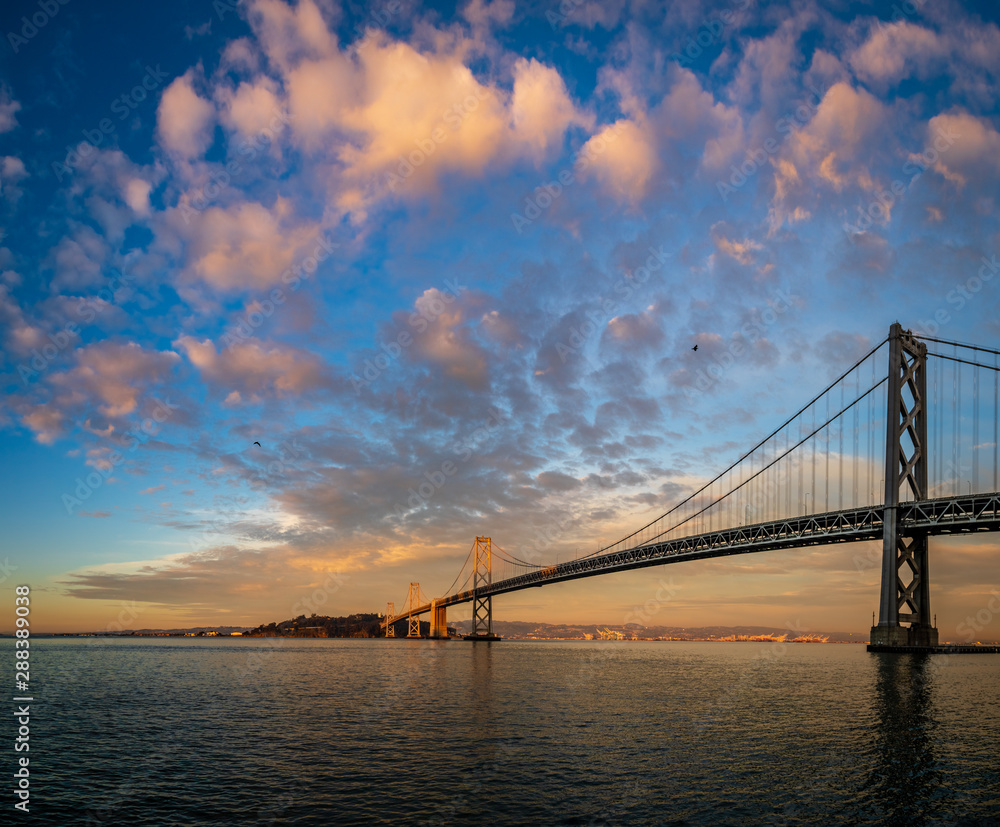 Colorful pink clouds over the San Francisco bay bridge with a bird Colorful pink clouds over the San Francisco bay bridge with a bird