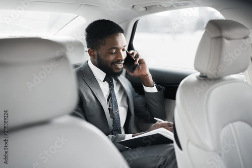 Businessman planning his day, going to office by car © Prostock-studio