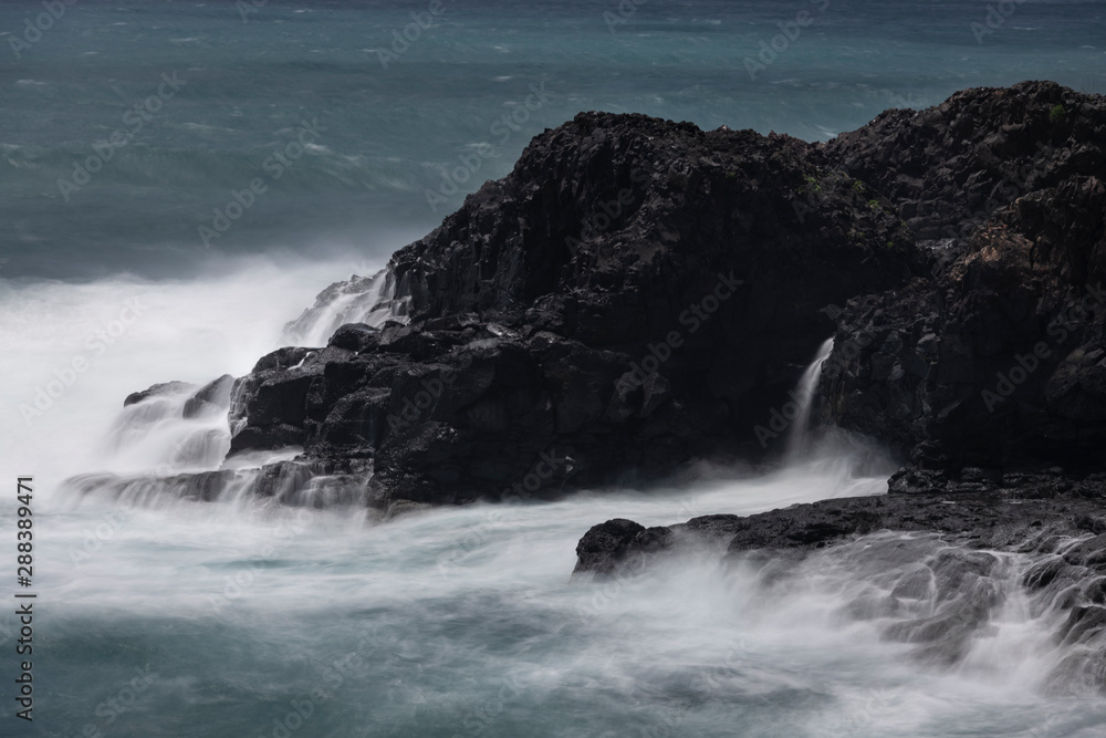 Rough seas with a slow shutter image of tide hitting the volcanic lava coastline of Sao Miguel.