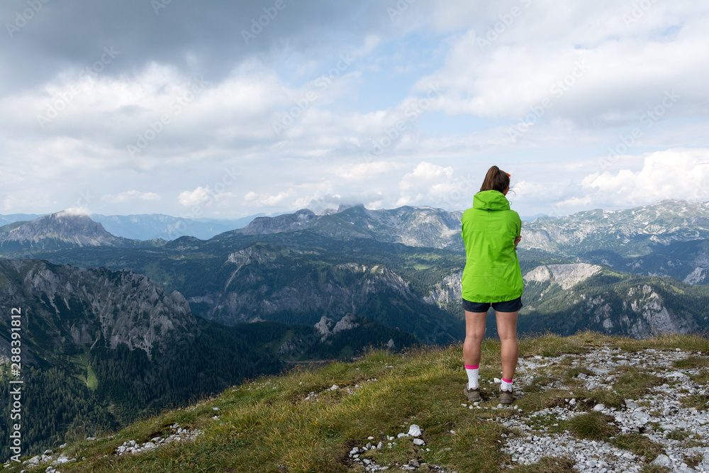 young hiker observing mountains horizon, Alps