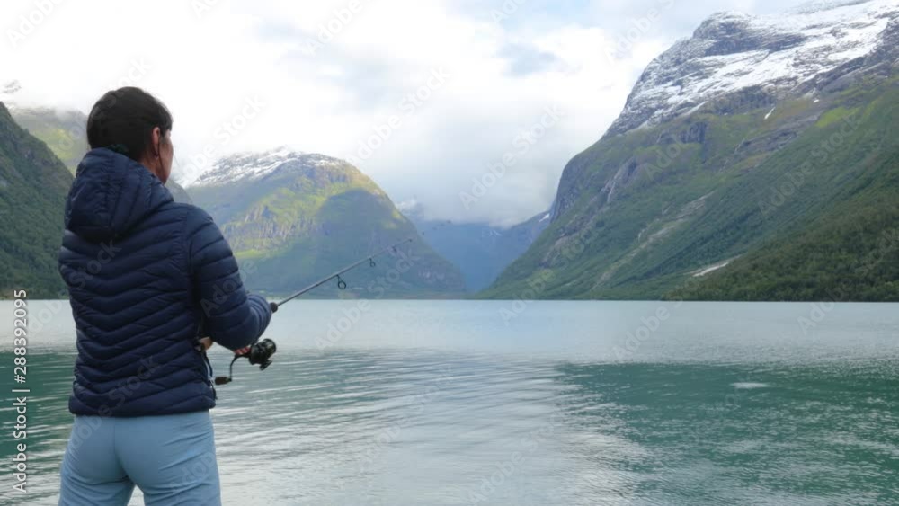 Woman fishing on Fishing rod spinning in Norway. Woman fishing on Fishing rod spinning in Norway.