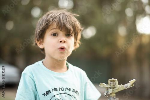 Bilde på lerret little three years old boy portraits in summer afternoon whistling