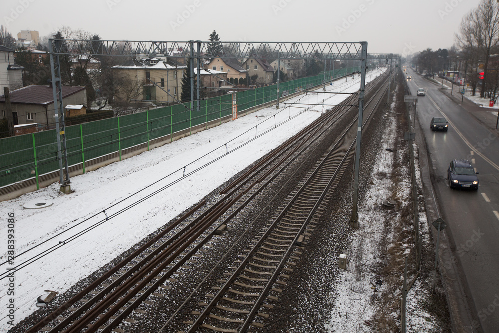 Naklejka premium Train tracks and a road, in a snowy day, Warsaw, Poland