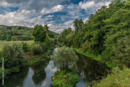 Ohre river in middle of summer with birch tree and tents