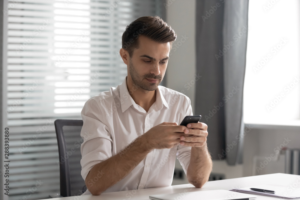 Serious young executive manager using internal company messenger application. Serious young executive manager using internal company messenger application.