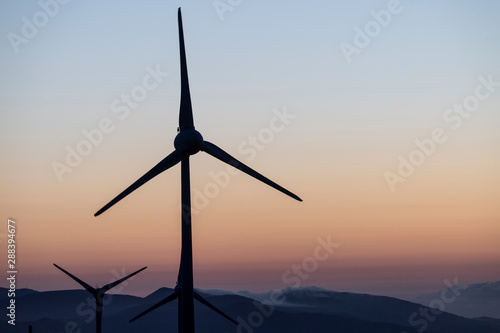 A wind far with wind turbines at Planalto dos Graminhais in a poetic sunset setting, serving as a perfect image for green sustainable renewable engery. photo