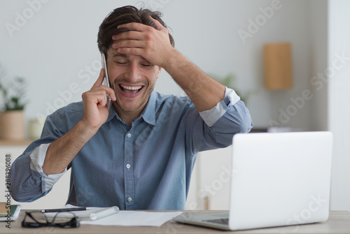 Принти на полотні Happy Young Man Having Phone Conversation Sitting In Office