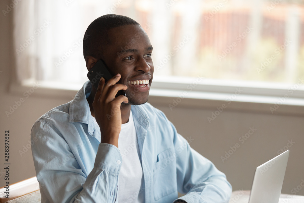 Smiling biracial man laugh having cellphone call Smiling biracial man laugh having cellphone call