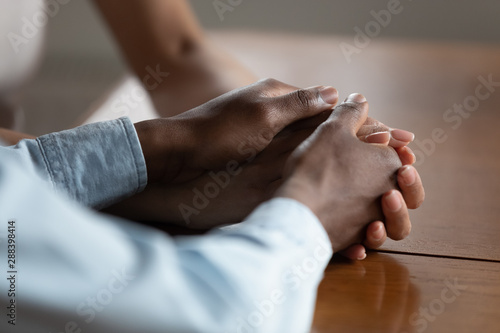 Close up of biracial couple hold hands showing love