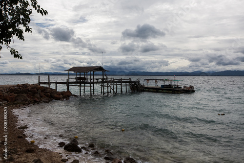 a rusty wooden boat dock on the rocky shore of Koh Talu Island near Hua HIn Thailand