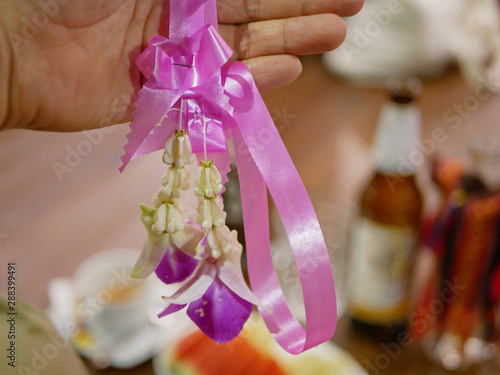 Selective focus of a welcome flower garland received before a meal at Khantok dinner - Northern Thai style meal which guests sit and eat on the floor photo