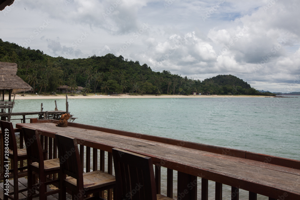 a Wooden bar table and chairs in front of the sea, Koh Talu Island, Thailand