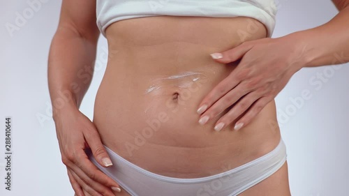 Wallpaper Mural Close-up of female applying cream or body lotion on her belly. The concept of beauty, cleanliness and skin care and body Torontodigital.ca
