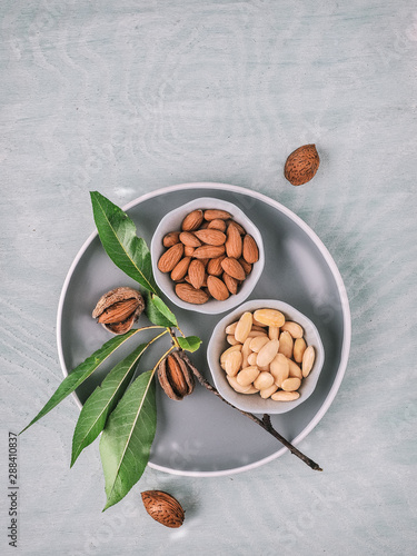 Almond tree branch with fresh almonds in bowls. Overhead shot.