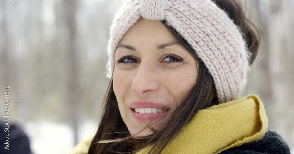 Happy woman smiling in winter wonderland - smiling towards camera Happy woman smiling in winter wonderland - smiling towards camera