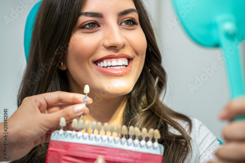 Fotografie Young woman with perfect teeth , looking how white are her teeth , with teeth sh