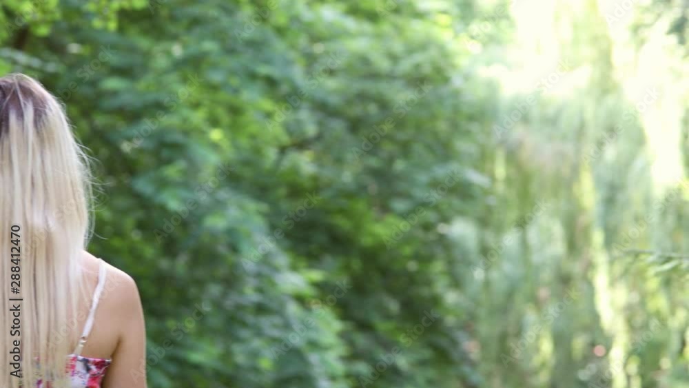 Pan towards beautiful blonde girl standing in the nature, shaking her hair then turning to the camera. Pan towards beautiful blonde girl standing in the nature, shaking her hair then turning to the camera.