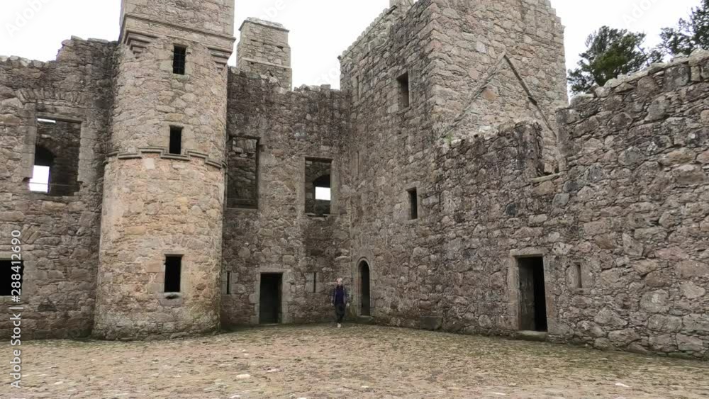 Lady comes out of tower door and walks over Tolquhon Castle courtyard Lady comes out of tower door and walks over Tolquhon Castle courtyard