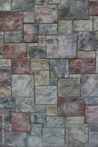 Colorful modern marble-like tile wall texture with blocks in varying hues of rose red, blue, and gray