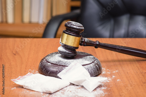 Drugs on the table of the judge. White powder on the judge's gavel.  Court for the sale of drugs. Verdict for the distribution of drugs.