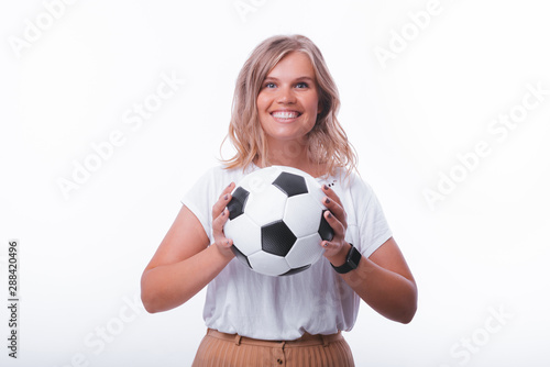 Photo of woman holding soccer ball, looking at camer over white background © Vulp