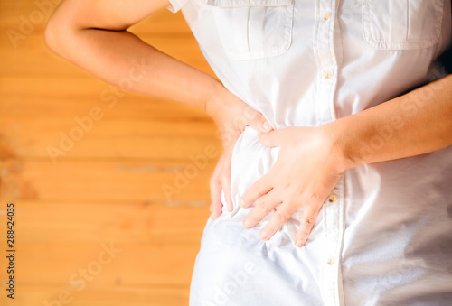 Woman's hand he is caught at the waist in the home.