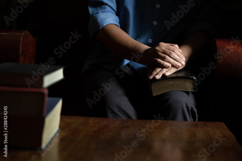 Family group are praying together on wooden table
