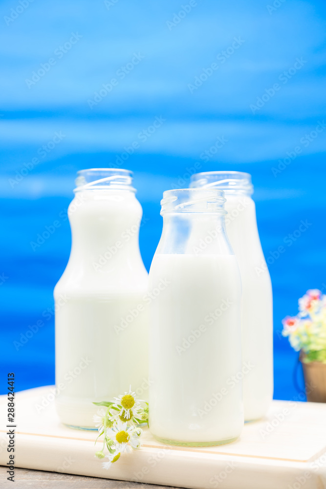 Three bottles of milk filled with milk Three bottles of milk filled with milk