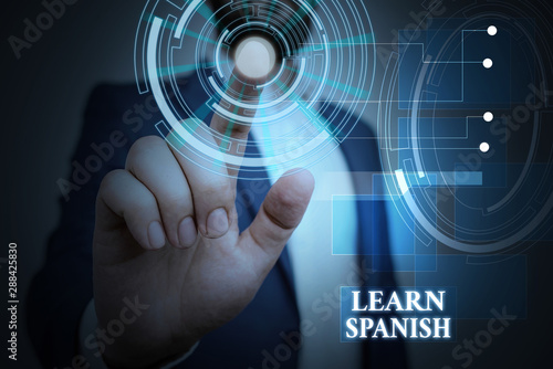 Handwriting text Learn Spanish. Conceptual photo Translation Language in Spain Vocabulary Dialect Speech Male human wear formal work suit presenting presentation using smart device