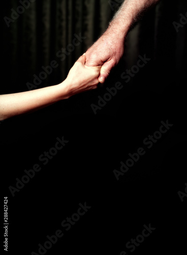 close up senior adult male hand and young adult female hand holding each other