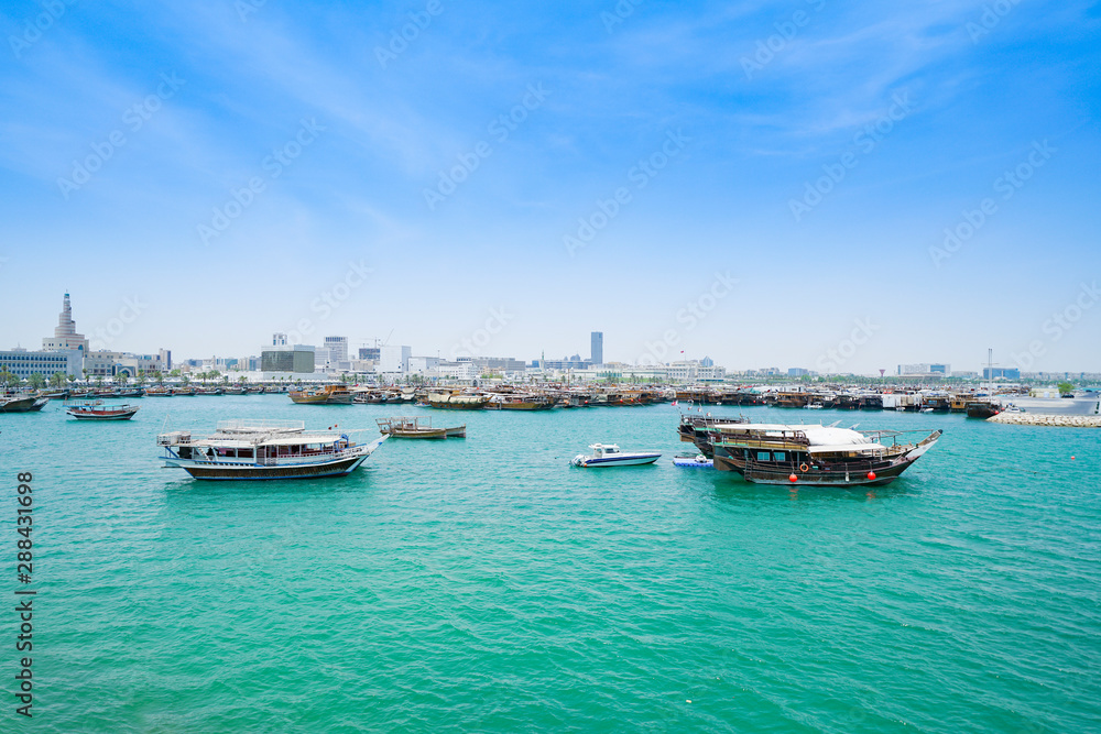Boats in  harbor Doha with turquoise Persian Gulf water Qatar.