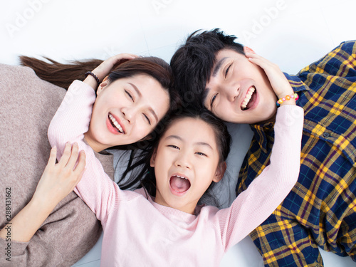 happy family lying on floor looking at camera