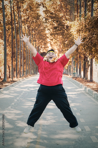 Overweight man exercising and jumping at park