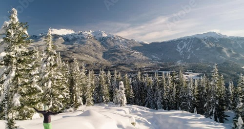 Woman Snowshoeing In The Mountains On A Sunny Day