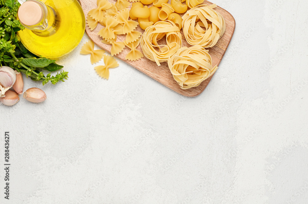 Different types of Italian pasta, fresh basil, olive oil and garlic