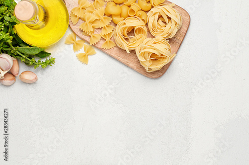 Different types of Italian pasta, fresh basil, olive oil and garlic