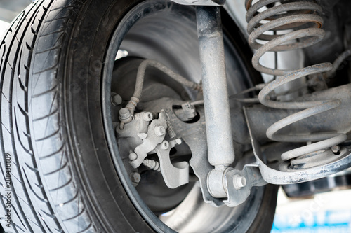 Close Up of Car Shock Absorber and Spring. it's dirty and Worn out in garage prepare to service and replacement.