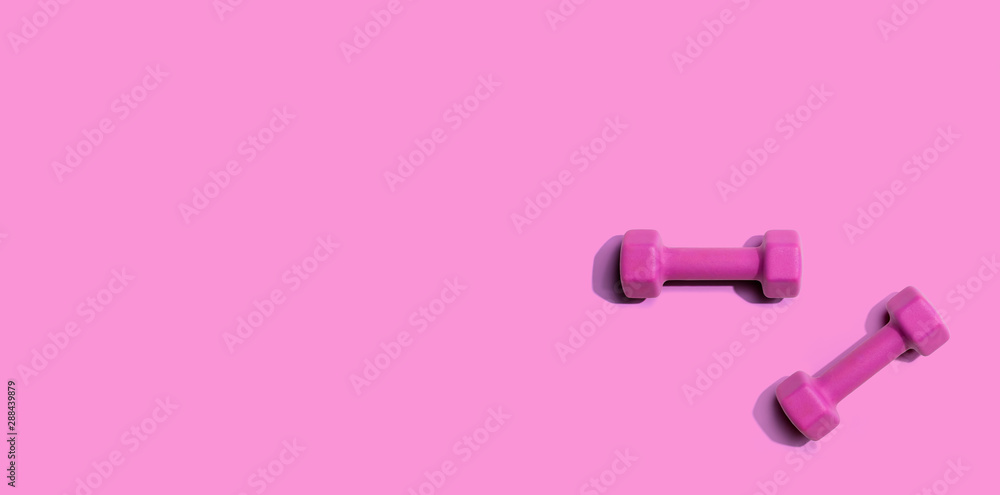 Dumbbells with hard shadow from above - overhead view Dumbbells with hard shadow from above - overhead view