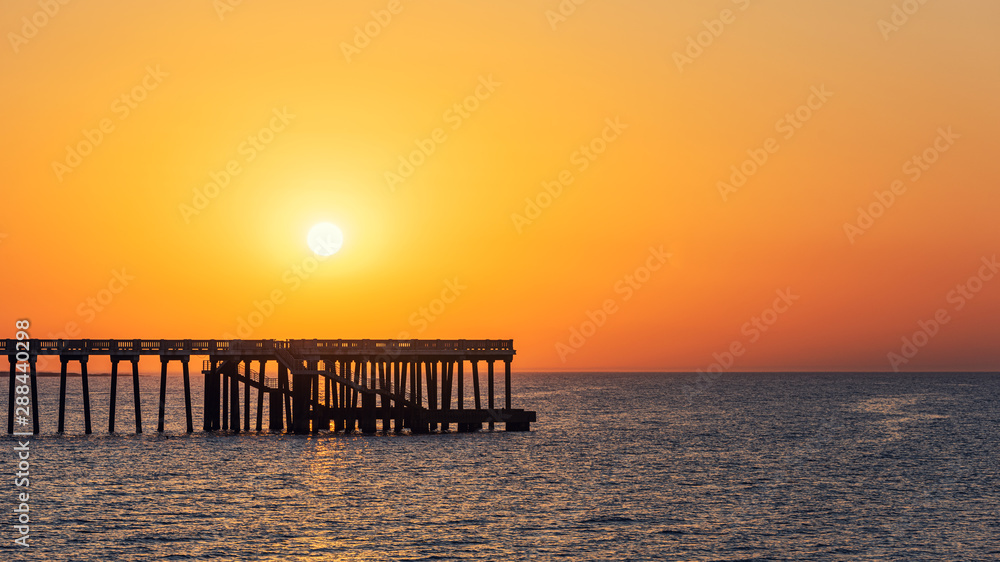 Sea pier against the sunset