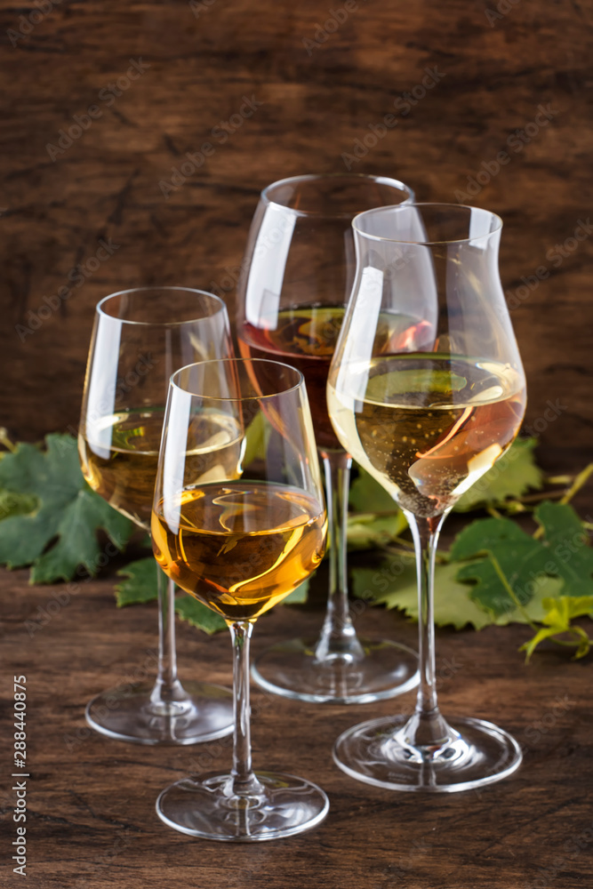White wine set. Wine tasting, the most popular varieties of white wines in wine glasses on vintage wooden table in rustic style, selective focus White wine set. Wine tasting, the most popular varieties of white wines in wine glasses on vintage wooden table in rustic style, selective focus