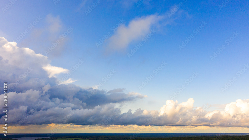 Obraz premium Aerial view White clouds in blue sky. Top view. View from drone. Aerial bird's eye view. Aerial top view cloudscape. Texture of clouds. View from above. Sunrise or sunset over clouds
