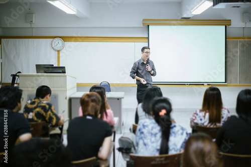 Teacher teaching studen in classroom at university.