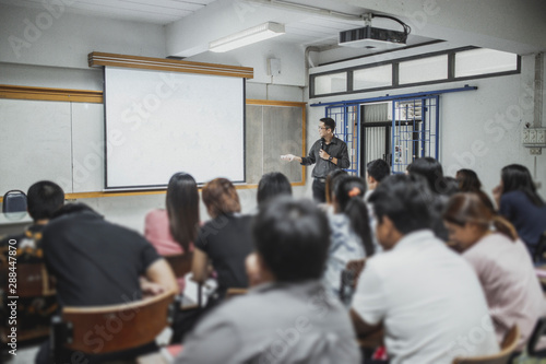 Teacher teaching studen in classroom at university.