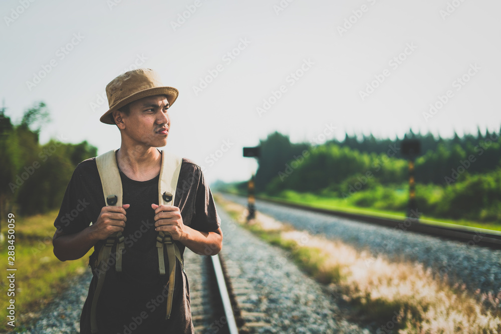 man with backpack walking away on railroad and emphasize to patience and survey trying step forward to goal. copy space