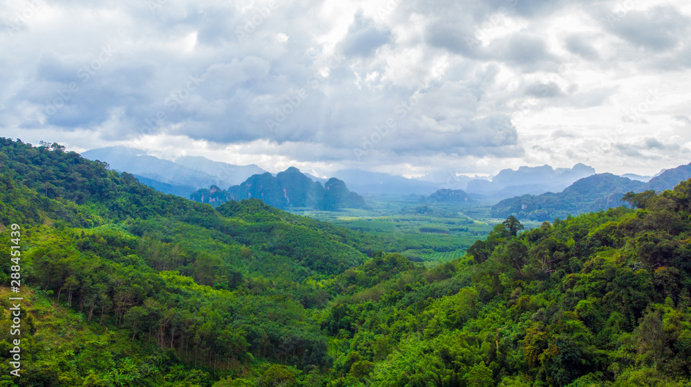 Winding road in mountain valley at sunset. Aerial view of asphalt road in thailand. Top view of roadway, mountains,Green forest, blue sky and sunlight Winding road in mountain valley at sunset. Aerial view of asphalt road in thailand. Top view of roadway, mountains,Green forest, blue sky and sunlight