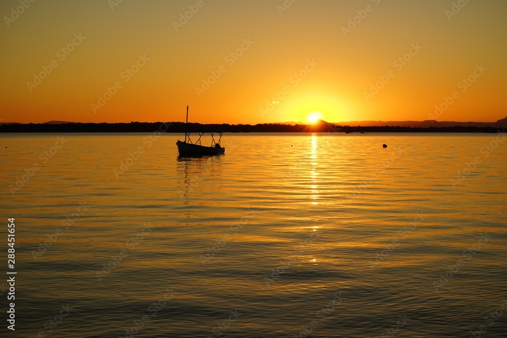 sun setting over calm water
