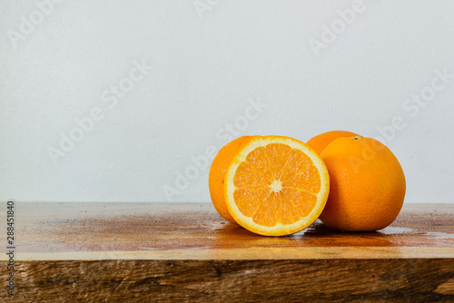 Close-up of oranges on a wooden table and a white background as a copy space.