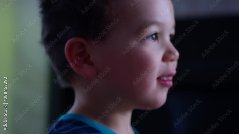 Toddler boy on christmas day is standing in amazement at presents