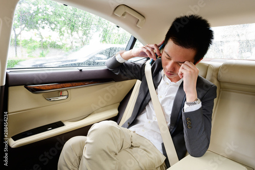 Stressed frustrated businessman talking on phone in the car