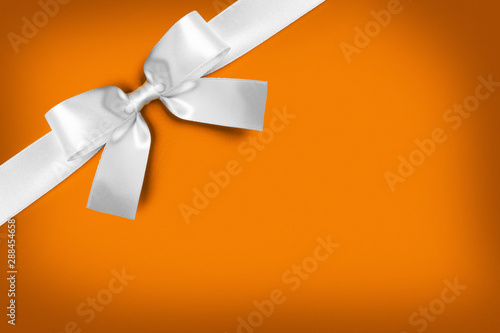 White gift bow on orange